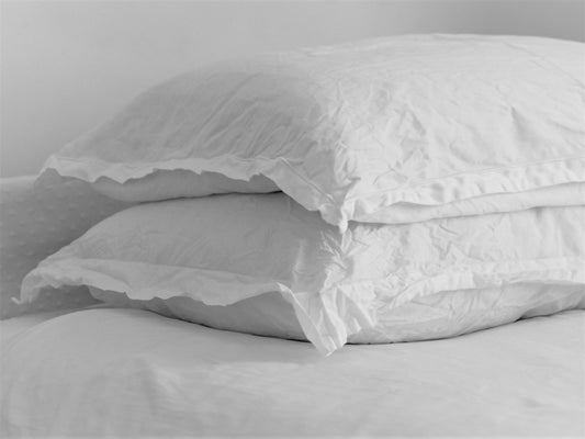 Pair of white comfy organic bed pillows on a bed